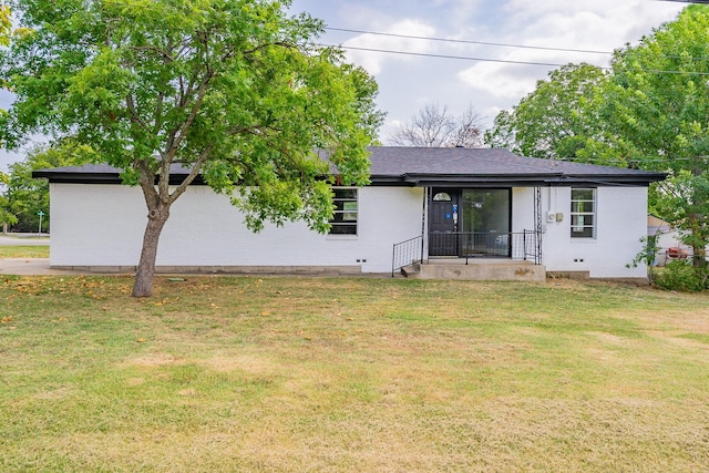 rear view of house with a lawn and brick siding