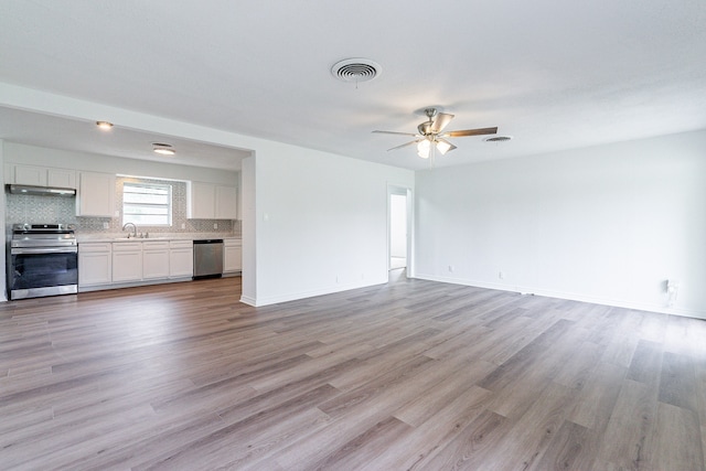 unfurnished living room with sink, light hardwood / wood-style flooring, and ceiling fan