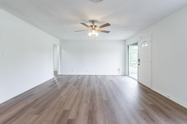 interior space featuring ceiling fan, baseboards, and wood finished floors