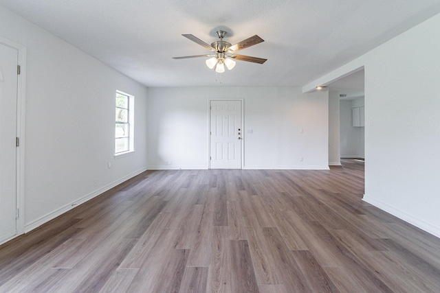 spare room with ceiling fan, baseboards, and wood finished floors