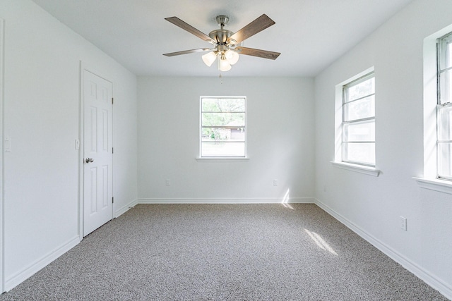 carpeted empty room featuring plenty of natural light, baseboards, and ceiling fan