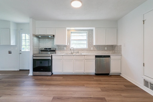 kitchen with stainless steel appliances, white cabinets, and a sink