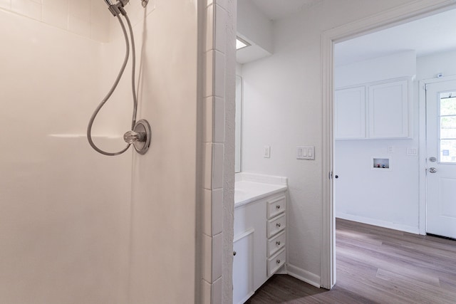 bathroom featuring hardwood / wood-style floors, walk in shower, and vanity