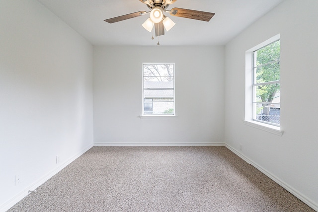 empty room featuring ceiling fan, a healthy amount of sunlight, and carpet