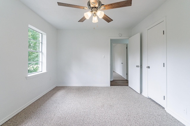 unfurnished bedroom featuring a ceiling fan, light colored carpet, and baseboards