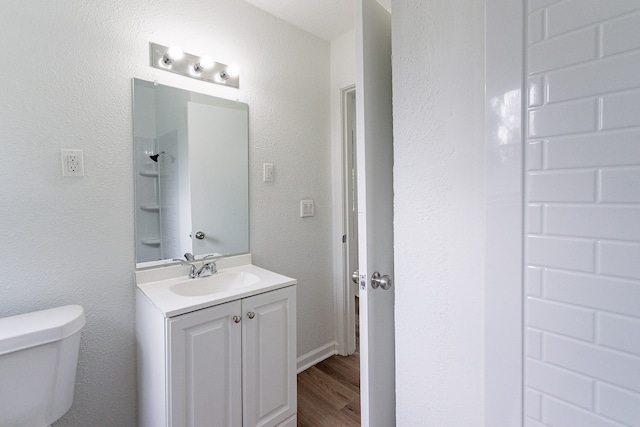 bathroom with vanity, hardwood / wood-style floors, and toilet