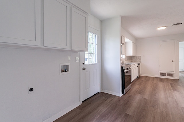 kitchen with white cabinets, stove, and wood-type flooring