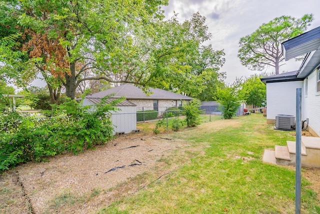 view of yard with fence and central air condition unit