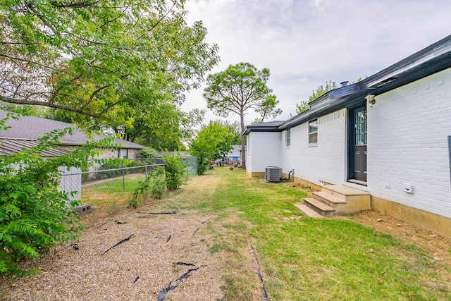 view of yard featuring central air condition unit and fence