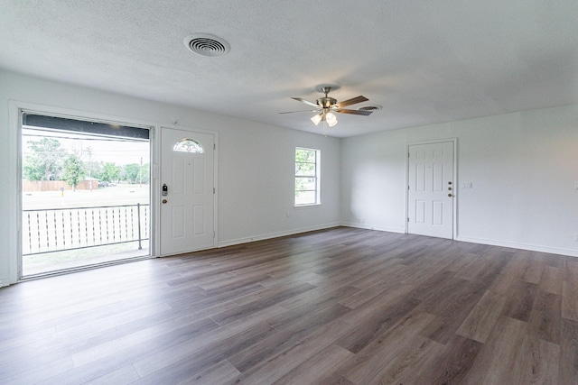 entryway featuring dark wood-style flooring, visible vents, a ceiling fan, a textured ceiling, and baseboards