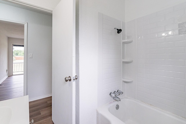 bathroom featuring shower / tub combination, baseboards, and wood finished floors