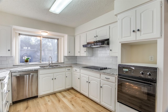 kitchen with sink, white cabinets, black appliances, and light hardwood / wood-style flooring