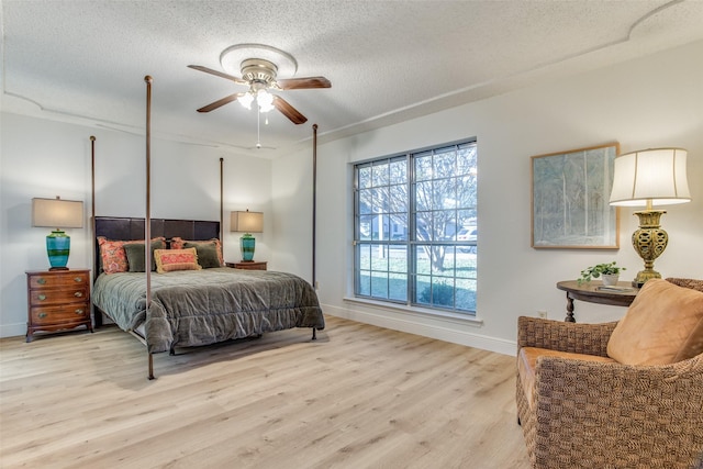 bedroom featuring a textured ceiling, light hardwood / wood-style flooring, and ceiling fan