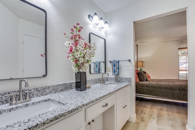 bathroom featuring vanity, a textured ceiling, and hardwood / wood-style flooring