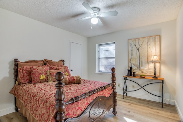 bedroom with ceiling fan, light hardwood / wood-style floors, and a textured ceiling