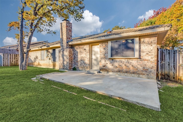 back of house featuring a patio area and a yard