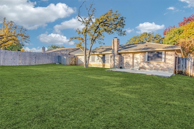 rear view of property featuring a lawn and a patio area