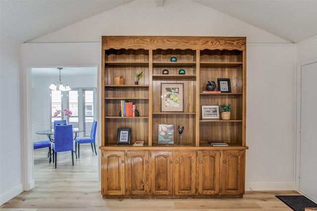 interior details featuring hardwood / wood-style flooring, a textured ceiling, and a chandelier