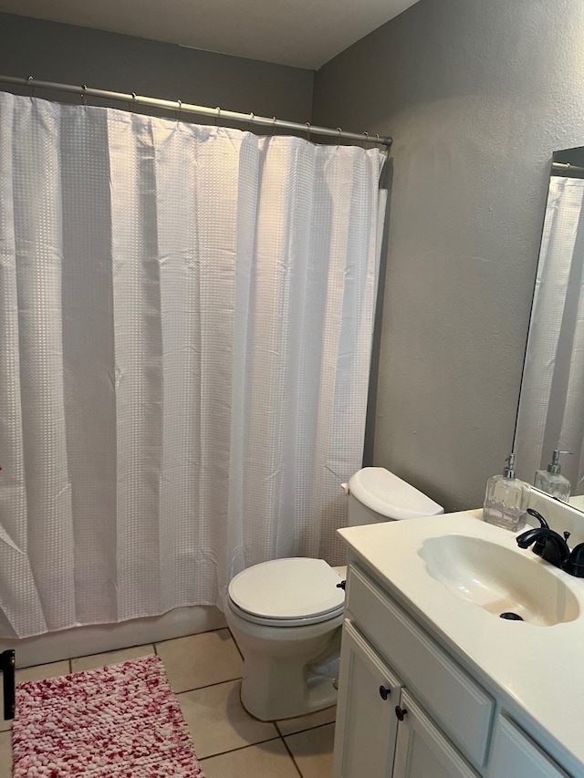 bathroom with tile patterned flooring, toilet, and vanity