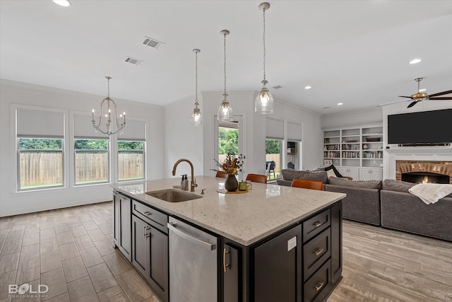 kitchen with ceiling fan with notable chandelier, light stone countertops, dishwasher, sink, and light wood-type flooring