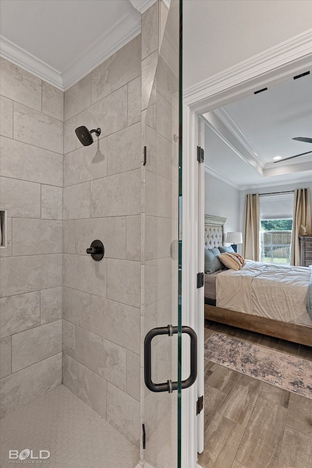 bathroom with crown molding, a shower with shower door, and wood-type flooring