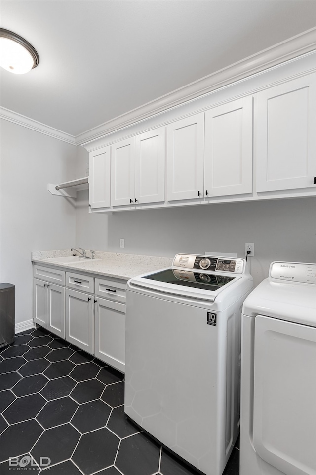 washroom featuring washer and clothes dryer, dark tile patterned floors, sink, cabinets, and ornamental molding