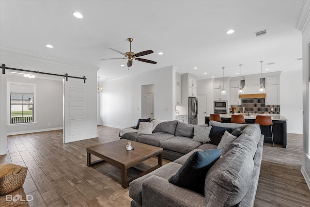 living room with crown molding, a barn door, ceiling fan, and dark hardwood / wood-style flooring