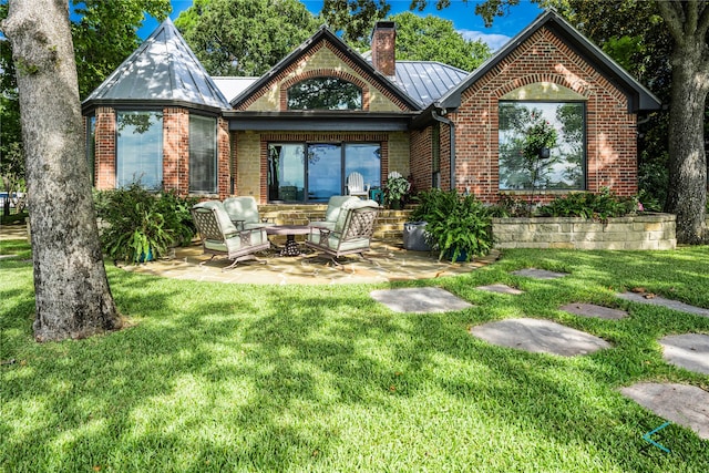 rear view of property with a lawn and a patio