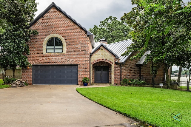 view of front of home with a garage and a front lawn