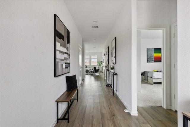 hallway with light hardwood / wood-style floors