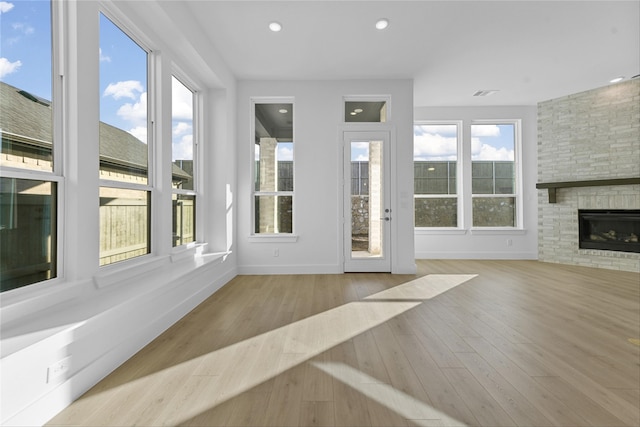 unfurnished sunroom with a fireplace and a wealth of natural light