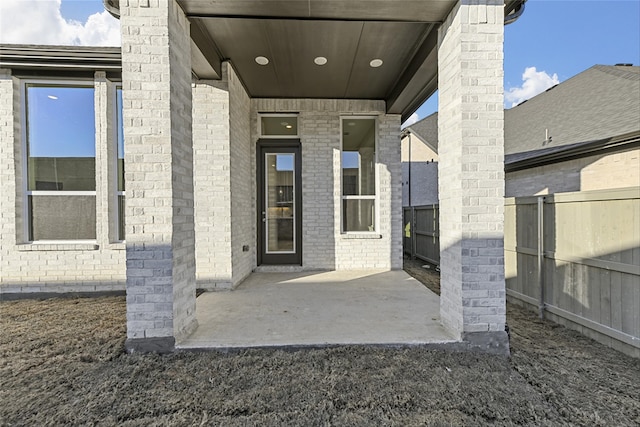 view of exterior entry featuring a patio area