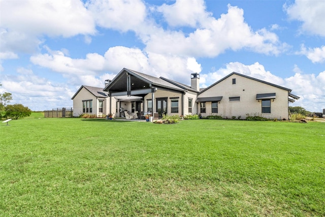 back of property featuring a lawn and a patio