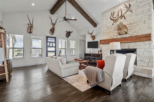 living room featuring ceiling fan, a fireplace, beamed ceiling, and dark hardwood / wood-style floors