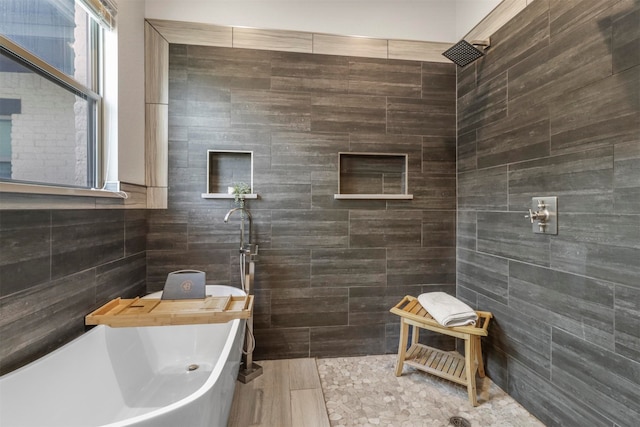 bathroom with tiled shower and tile walls