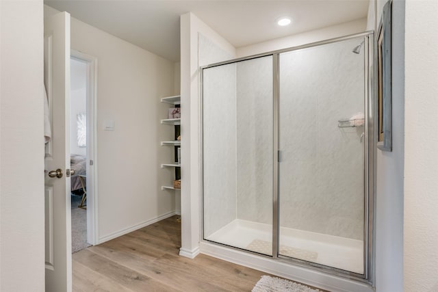 bathroom featuring hardwood / wood-style floors and a shower with shower door