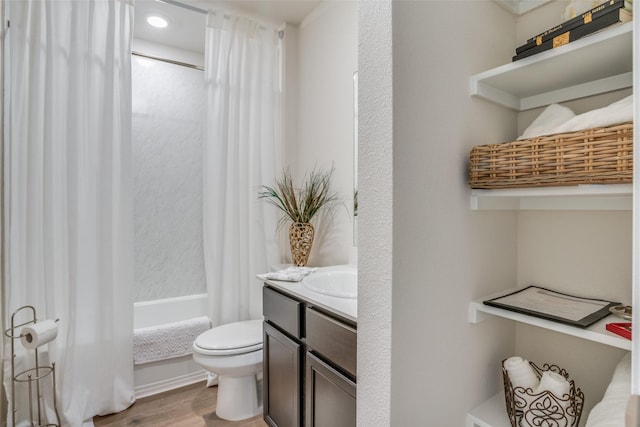 full bathroom featuring hardwood / wood-style floors, vanity, shower / bath combo, and toilet