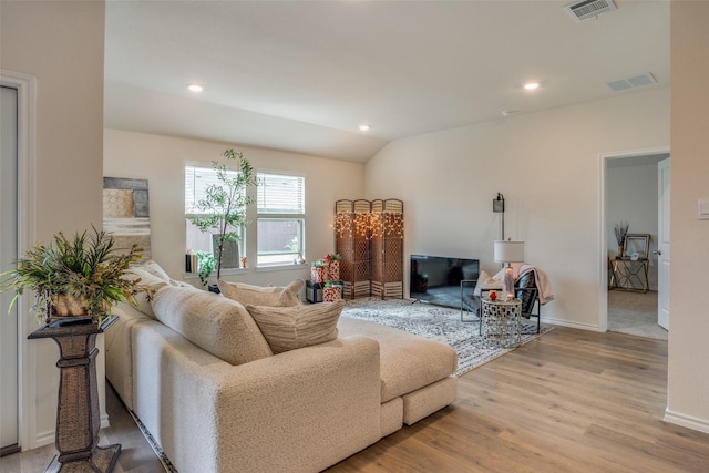 living room with light wood-type flooring and vaulted ceiling