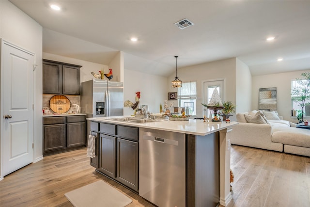 kitchen with appliances with stainless steel finishes, an island with sink, plenty of natural light, and sink