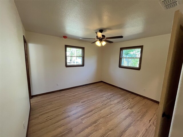 spare room with ceiling fan, light hardwood / wood-style flooring, and a textured ceiling