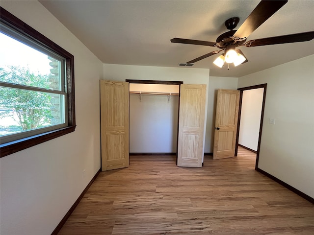 unfurnished bedroom featuring ceiling fan, a closet, and hardwood / wood-style floors