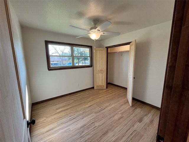 unfurnished bedroom with ceiling fan, light wood-type flooring, and a closet