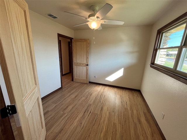 empty room with ceiling fan and wood-type flooring