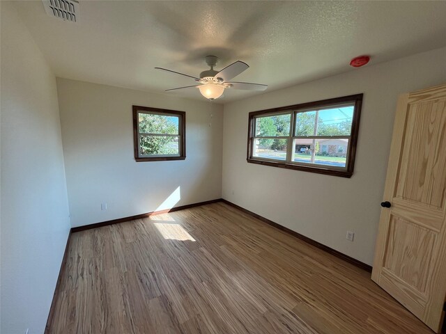 unfurnished room featuring ceiling fan, hardwood / wood-style flooring, and a textured ceiling