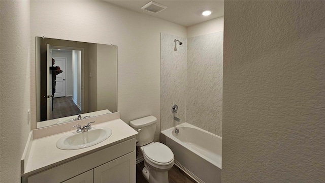 full bathroom featuring tiled shower / bath, vanity, and toilet