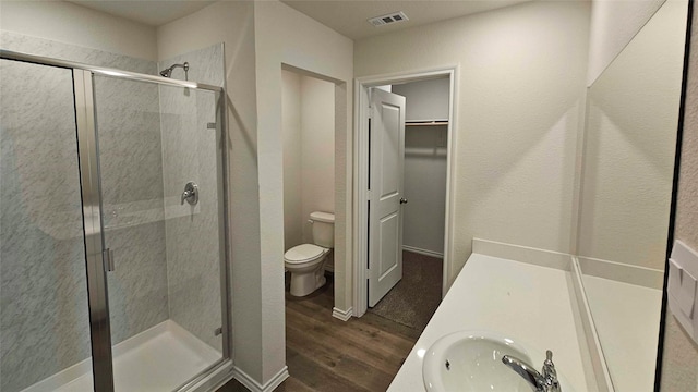 bathroom featuring a shower with door, wood-type flooring, vanity, and toilet