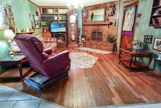 living room featuring hardwood / wood-style floors, a chandelier, and a brick fireplace