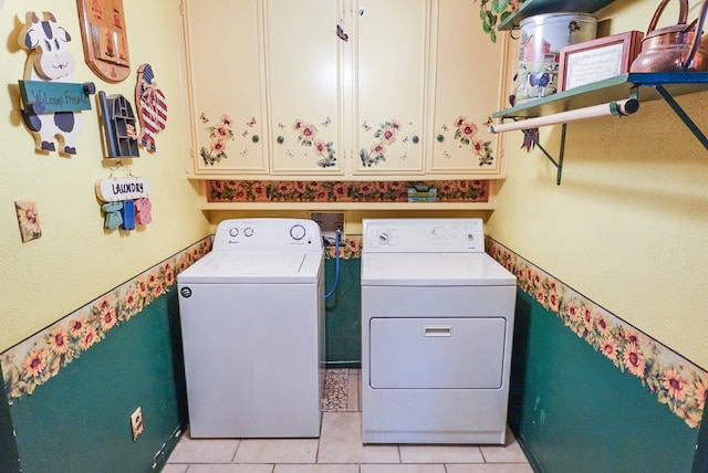 clothes washing area featuring cabinets, light tile patterned floors, and separate washer and dryer