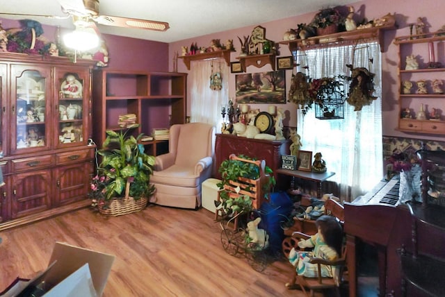 living area with light hardwood / wood-style flooring, a wealth of natural light, and ceiling fan