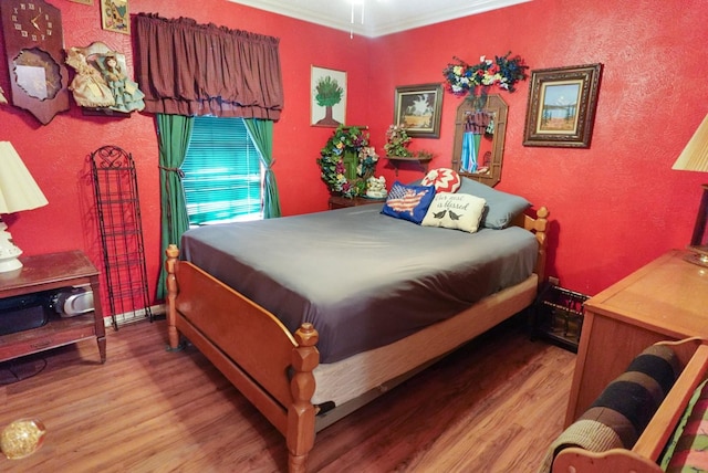 bedroom with crown molding and hardwood / wood-style floors